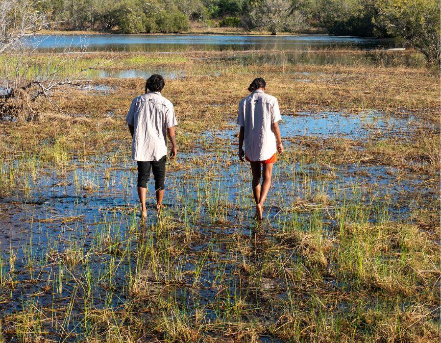 River Keepers Trinity and Jasmine walking through wetlands at Mangkajarra
